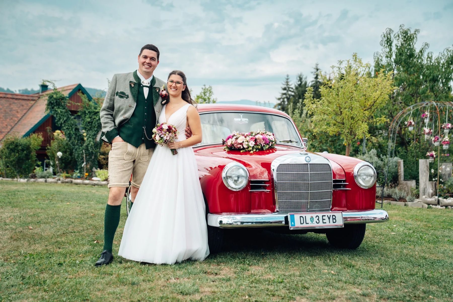 Brautpaar vor einem roten Oldtimer